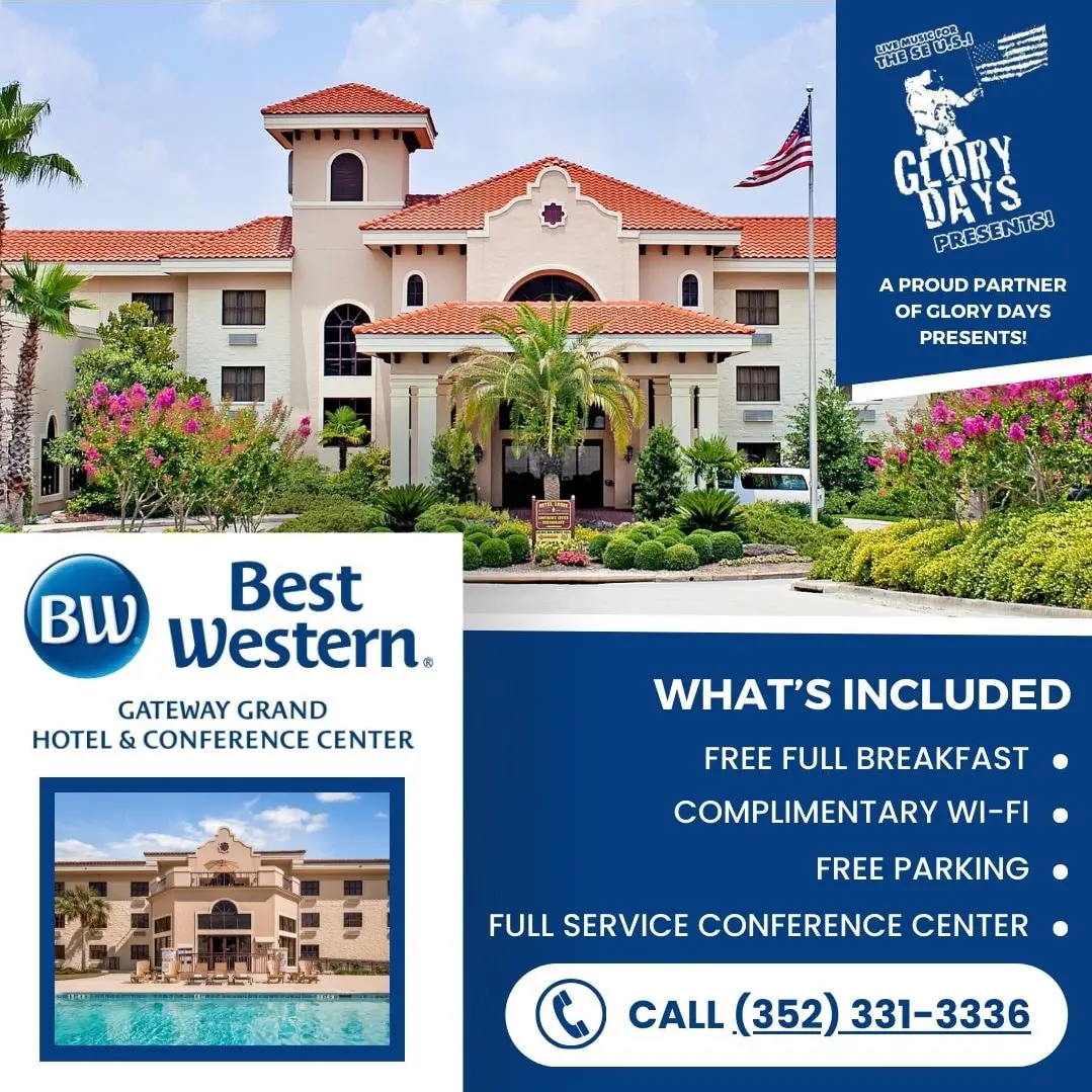 The exterior of the Best Western Gateway Grand Hotel, a large Spanish-style building with a red tile roof, lush landscaping, and an American flag flying.